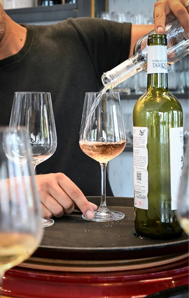 Verres de vin rosé et bouteille de vin posés sur le comptoir du bar des Platanes.