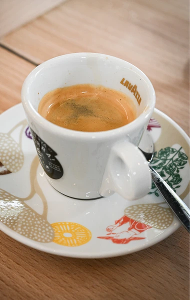 Tasse de café expresso servie sur une soucoupe blanche.